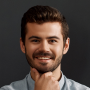 Feedback image, A man with a beard and shirt smiles at the camera, presenting a welcoming and professional appearance.