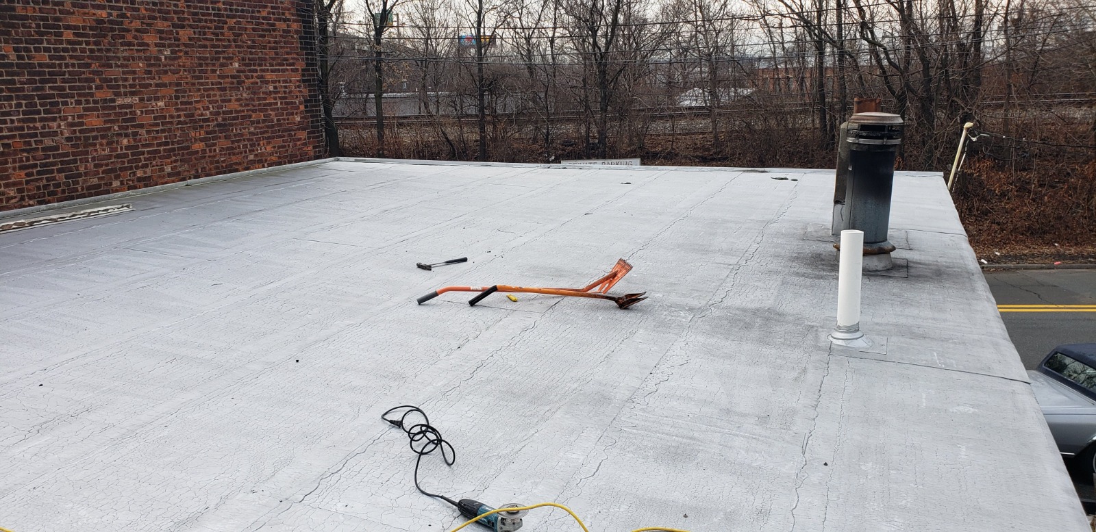 An image of a roof with a metal pole and ladder, highlighting professional modified roofing services in New Jersey.
