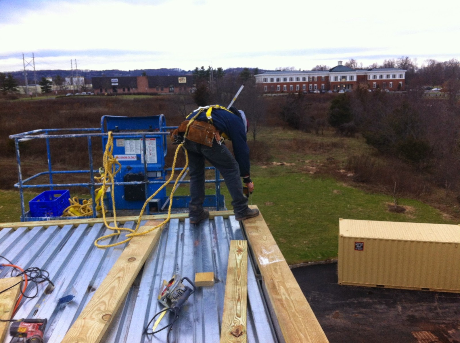 A man working on a metal roof, performing roofing modifications in New Jersey for residential and commercial properties.